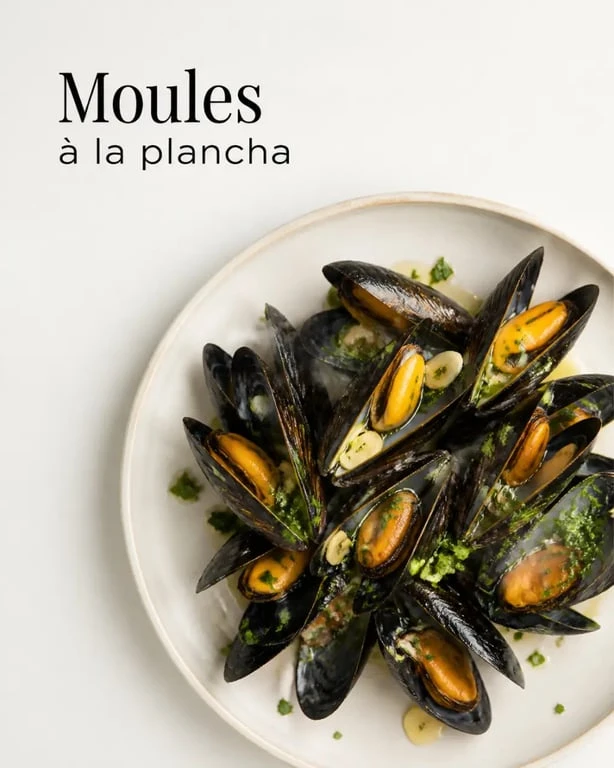 Moules a la plancha servies chaudes avec ail et persil en assiette
